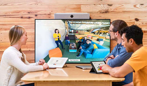 Office workers conferencing with a remote group of people, in a Collaboration / Huddle Space