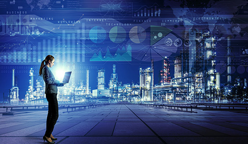 Female engineer standing in front of an industrial complex working on a laptop