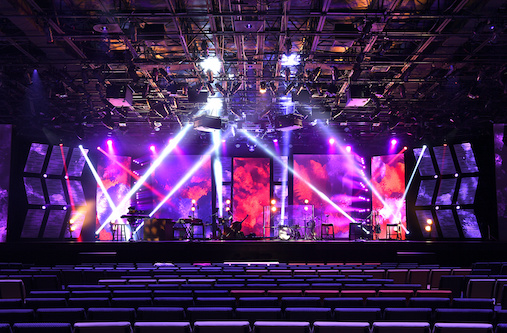 Professionals sitting in a large conference room and videoconferencing with a large projection screen